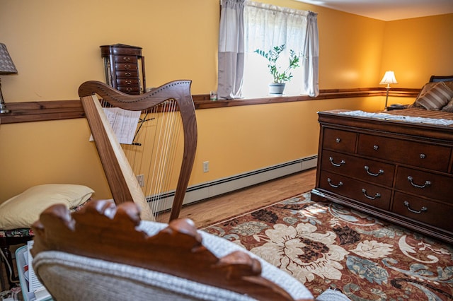 bedroom with a baseboard radiator and wood finished floors