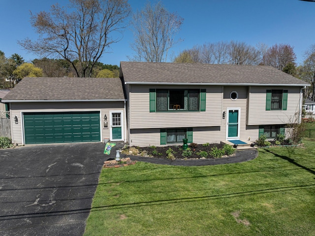 raised ranch with driveway, a garage, a front lawn, and a shingled roof