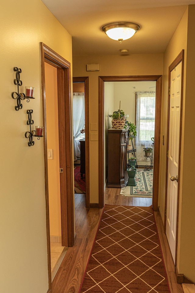 corridor featuring wood finished floors and baseboards