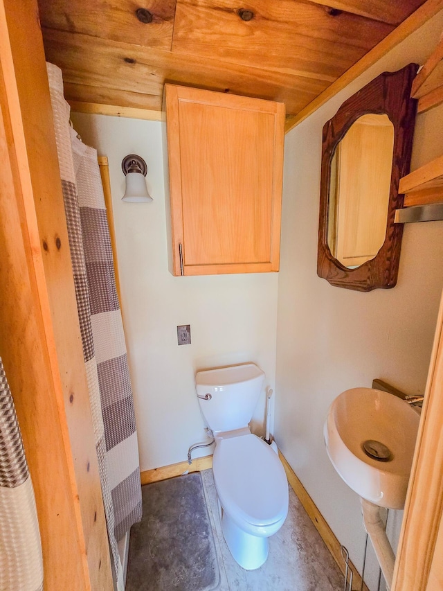 full bathroom with a sink, toilet, baseboards, curtained shower, and wood ceiling
