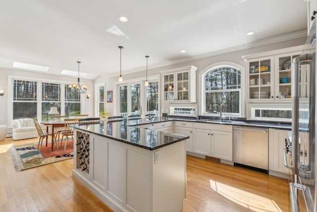 kitchen with light wood-type flooring, a sink, dishwasher, and a chandelier