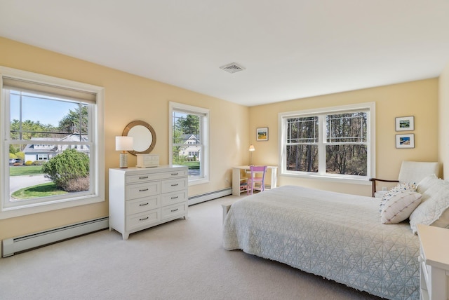bedroom featuring a baseboard heating unit, visible vents, and light carpet