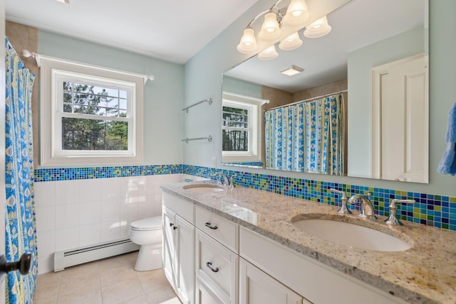 bathroom featuring toilet, a sink, baseboard heating, and tile patterned flooring