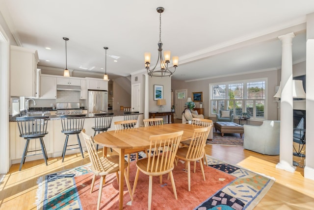 dining space with recessed lighting, ornamental molding, light wood finished floors, and a chandelier