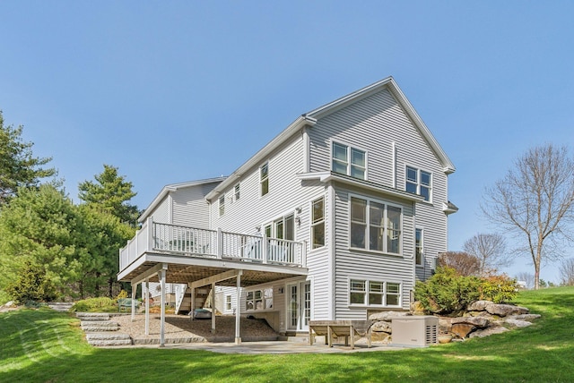 back of property with a lawn, a deck, stairs, and a patio area