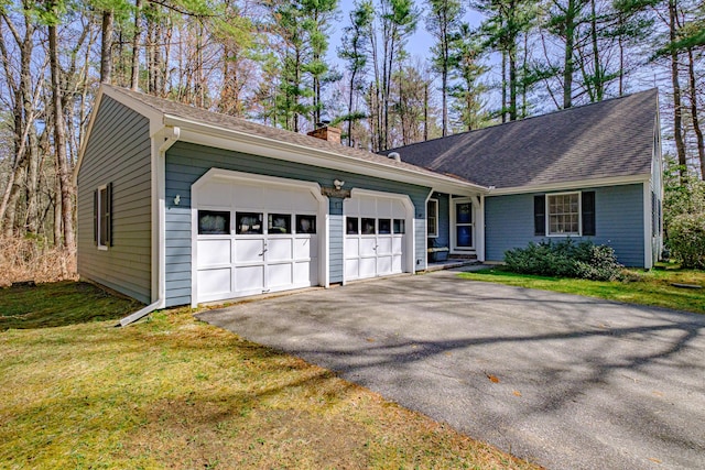 ranch-style house with a garage, a chimney, driveway, and a front yard