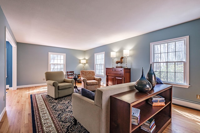 living area with baseboards, plenty of natural light, and light wood-style floors