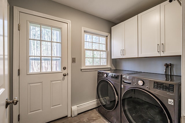 laundry room featuring plenty of natural light, baseboard heating, cabinet space, and washing machine and clothes dryer