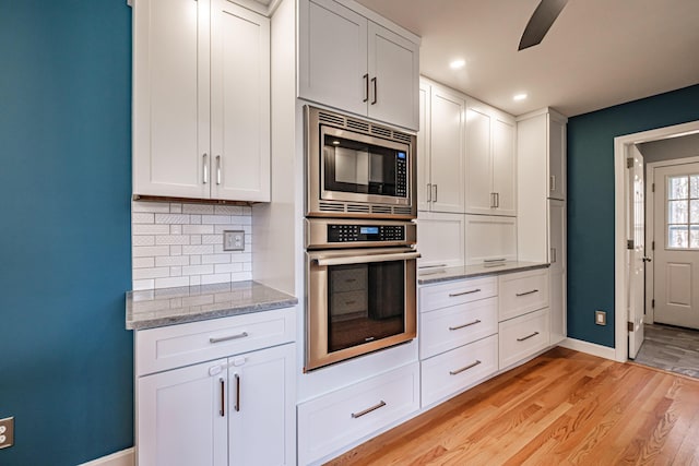 kitchen featuring light wood finished floors, stainless steel appliances, baseboards, recessed lighting, and backsplash