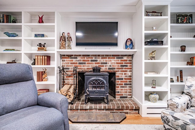 living area with a wood stove and wood finished floors