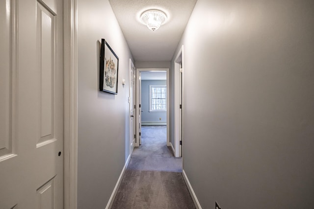 corridor featuring carpet flooring, baseboards, and a baseboard heating unit