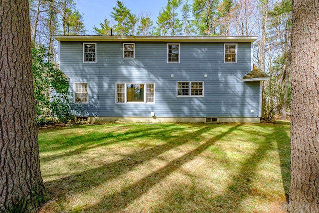 rear view of property featuring a lawn