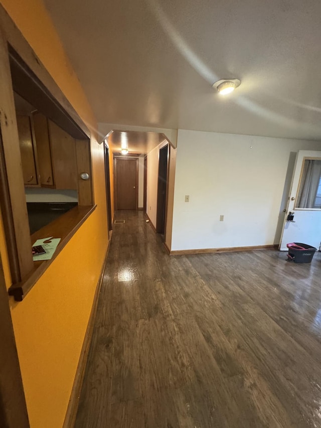 hall with baseboards and dark wood-style floors