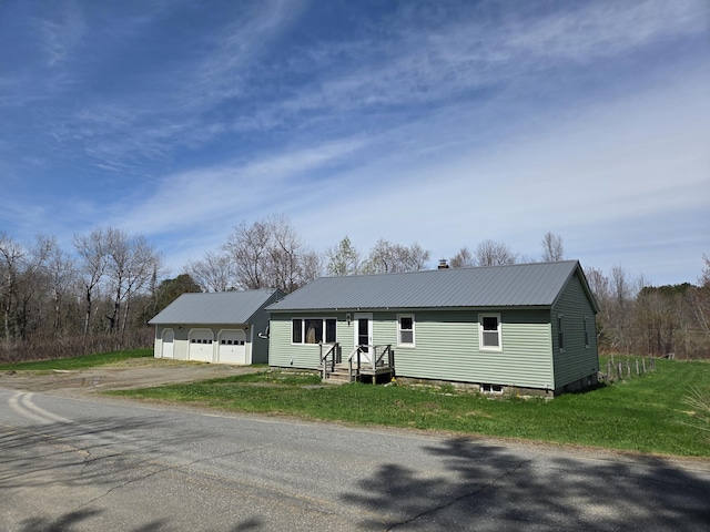 single story home featuring driveway, a garage, a front yard, metal roof, and a chimney