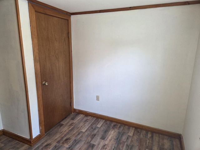 empty room with baseboards and dark wood finished floors