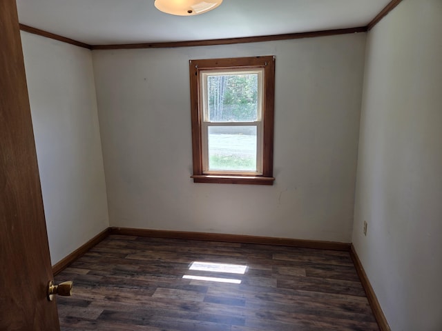 unfurnished room with baseboards, ornamental molding, and dark wood finished floors