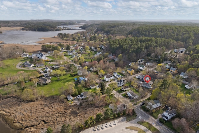birds eye view of property featuring a water view and a wooded view