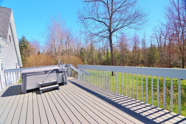 wooden terrace featuring a yard and a hot tub