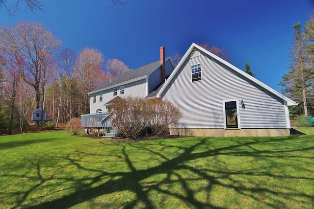 back of house featuring a wooden deck and a yard