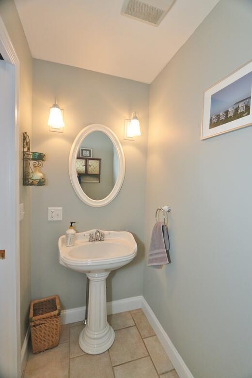 bathroom featuring baseboards, visible vents, a sink, and tile patterned flooring