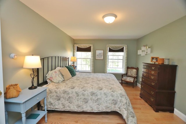 bedroom with baseboards and light wood finished floors