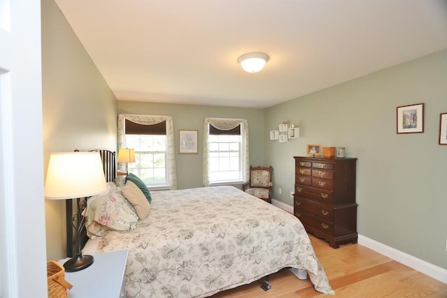 bedroom with baseboards and light wood finished floors