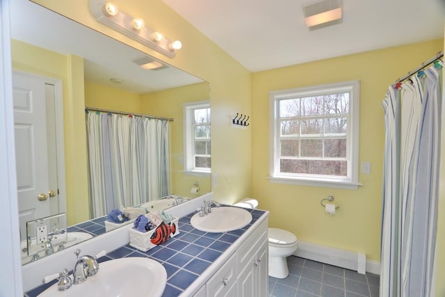bathroom featuring a sink, tile patterned floors, baseboard heating, and toilet