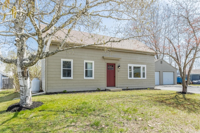 view of front of home featuring a front lawn, an outbuilding, and a detached garage