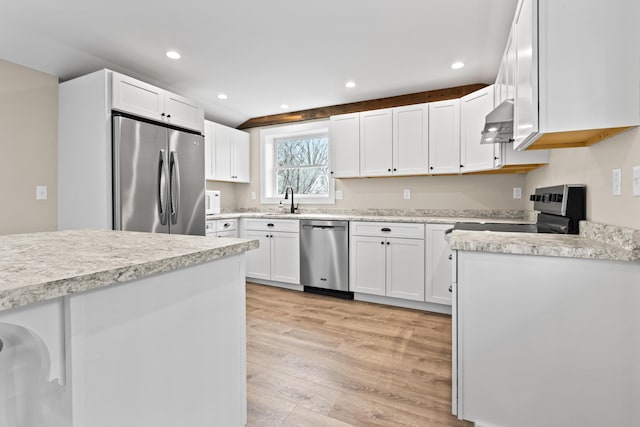 kitchen with light countertops, under cabinet range hood, white cabinets, light wood finished floors, and appliances with stainless steel finishes