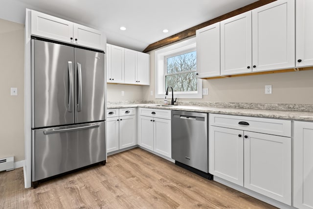 kitchen with light wood-style floors, recessed lighting, white cabinetry, a sink, and appliances with stainless steel finishes