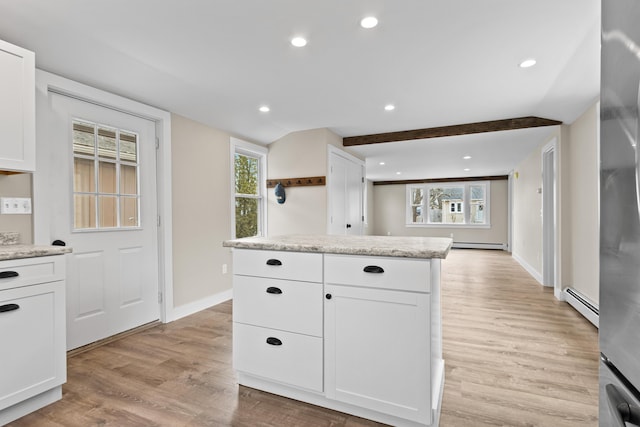 kitchen featuring a baseboard radiator, a baseboard heating unit, light wood finished floors, and white cabinets
