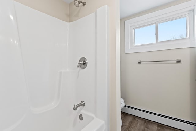 full bath with toilet, shower / washtub combination, baseboard heating, and wood finished floors