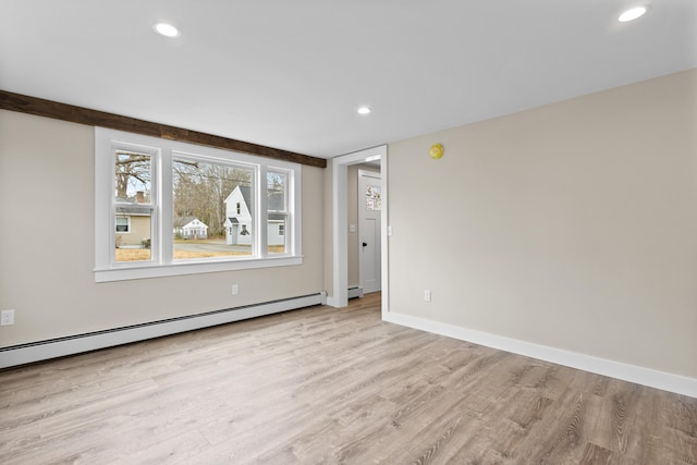 empty room featuring light wood-style floors, baseboards, a baseboard heating unit, and recessed lighting