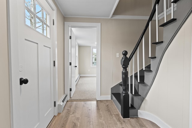 entrance foyer with a baseboard radiator, light wood finished floors, and a wealth of natural light