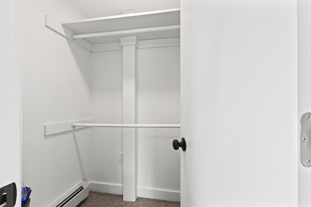 spacious closet featuring carpet floors and baseboard heating