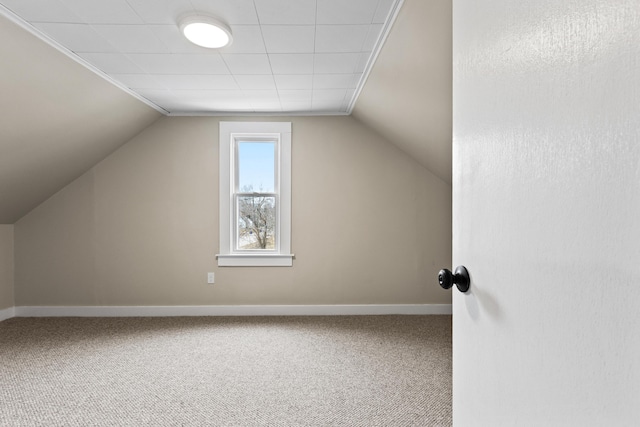 additional living space with carpet flooring, baseboards, and vaulted ceiling