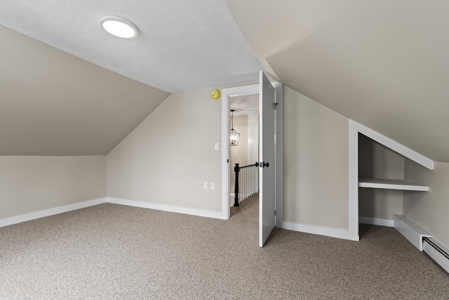 additional living space featuring carpet floors, baseboards, and lofted ceiling