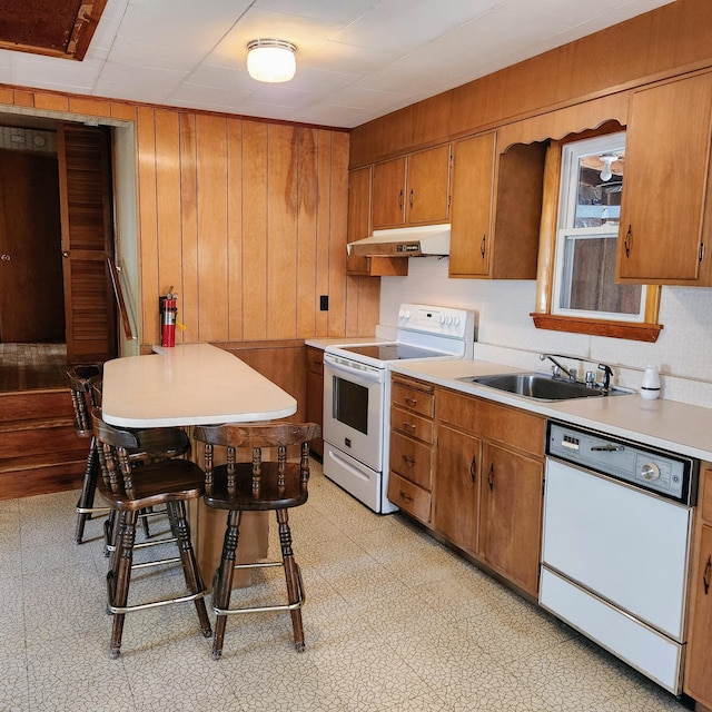 34 Chase Ave, Mexico, ME 04257 - kitchen with white appliances, under cabinet range hood, a sink, light countertops, and wooden walls