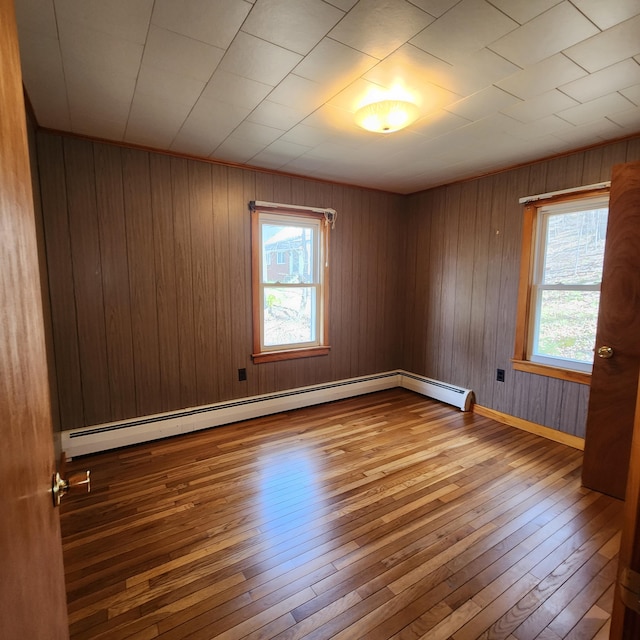 34 Chase Ave, Mexico, ME 04257 - empty room with wood-type flooring, healthy amount of natural light, baseboard heating, wooden walls, and baseboards