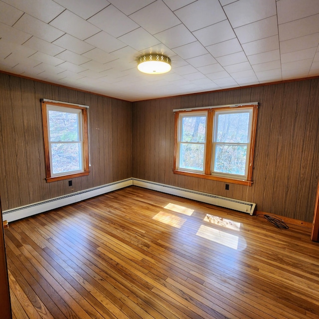 34 Chase Ave, Mexico, ME 04257 - spare room featuring a baseboard heating unit, hardwood / wood-style flooring, and wood walls