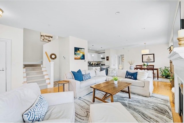 75 Clearwater Dr Unit 305, Falmouth, ME 04105 - living room with stairway, a fireplace, and light wood-type flooring