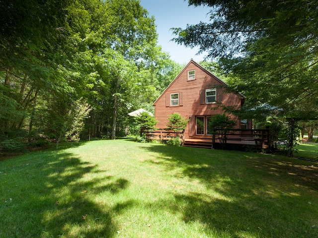 rear view of house with a yard and a deck