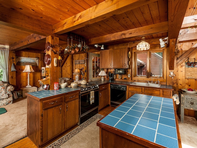 kitchen with tile countertops, wood walls, a sink, and black appliances