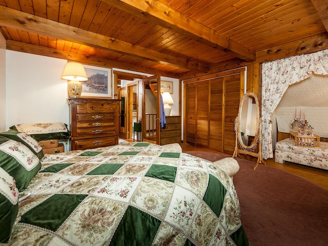 bedroom with wood walls, beam ceiling, wood finished floors, wooden ceiling, and a closet