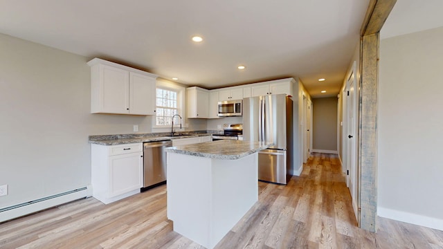 12 Marble Ln, Dixfield, ME 04224 - kitchen featuring stainless steel appliances, a sink, a baseboard radiator, a kitchen island, and white cabinetry