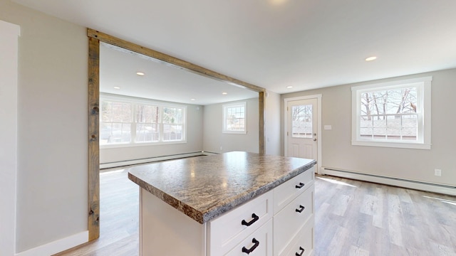 12 Marble Ln, Dixfield, ME 04224 - kitchen featuring a baseboard heating unit, light wood-style floors, white cabinetry, a kitchen island, and baseboard heating