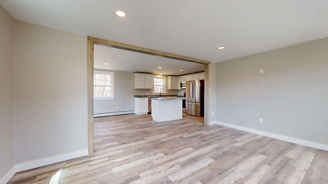 12 Marble Ln, Dixfield, ME 04224 - unfurnished living room featuring a baseboard heating unit, light wood finished floors, recessed lighting, baseboards, and a sink