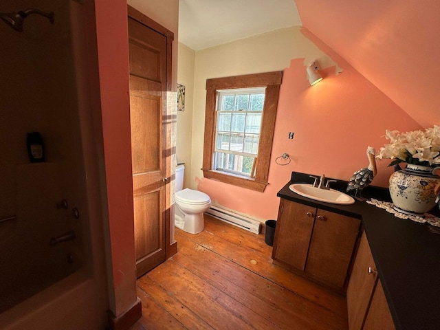 344 Main St, Lincoln, ME 04457 - bathroom with wood-type flooring, vanity, lofted ceiling, toilet, and baseboard heating