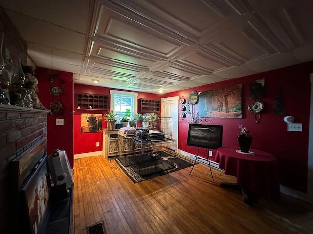 344 Main St, Lincoln, ME 04457 - living area with visible vents, a fireplace, baseboards, baseboard heating, and hardwood / wood-style flooring