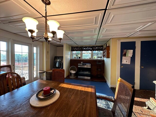 344 Main St, Lincoln, ME 04457 - dining room featuring washer / dryer, baseboards, an ornate ceiling, and a notable chandelier